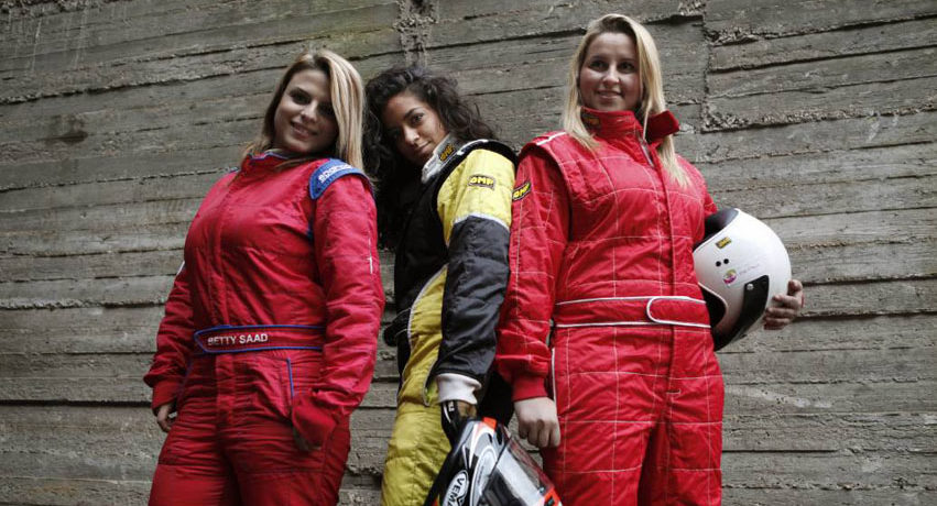 Three of the racing team pose in their racing suits.